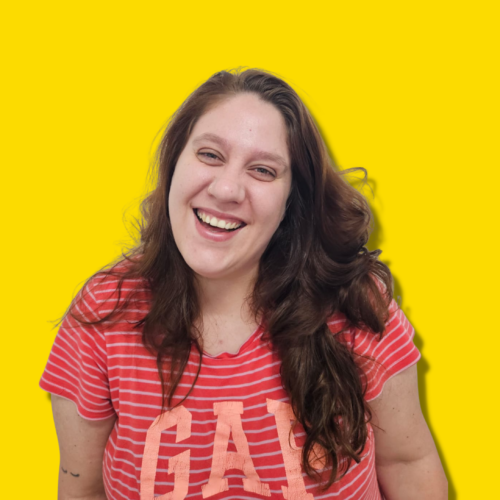Foto de Julia, representando a energia contagiante e o sucesso da Gente e Gestão, com um sorriso brilhante e um fundo amarelo vibrante