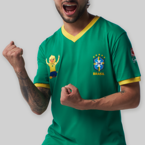 Camiseta verde do Guaraná com uma temática da Copa do Mundo. A camiseta apresenta o brasão do Brasil em destaque, com suas cores vibrantes e elementos característicos